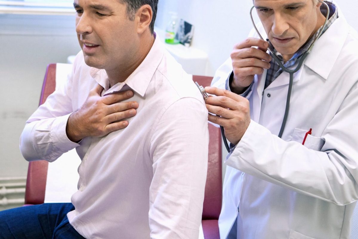Doctor listening to lungs of patient with asthma and breathing difficulties
