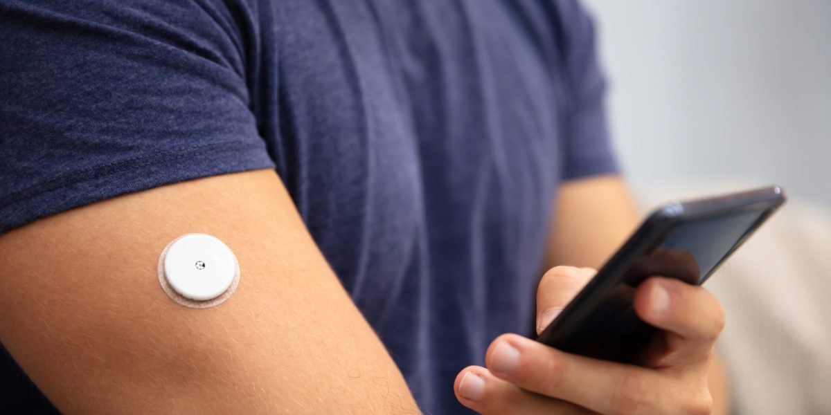 diabetic man using FreeStyle Libre Three glucose monitor sensor